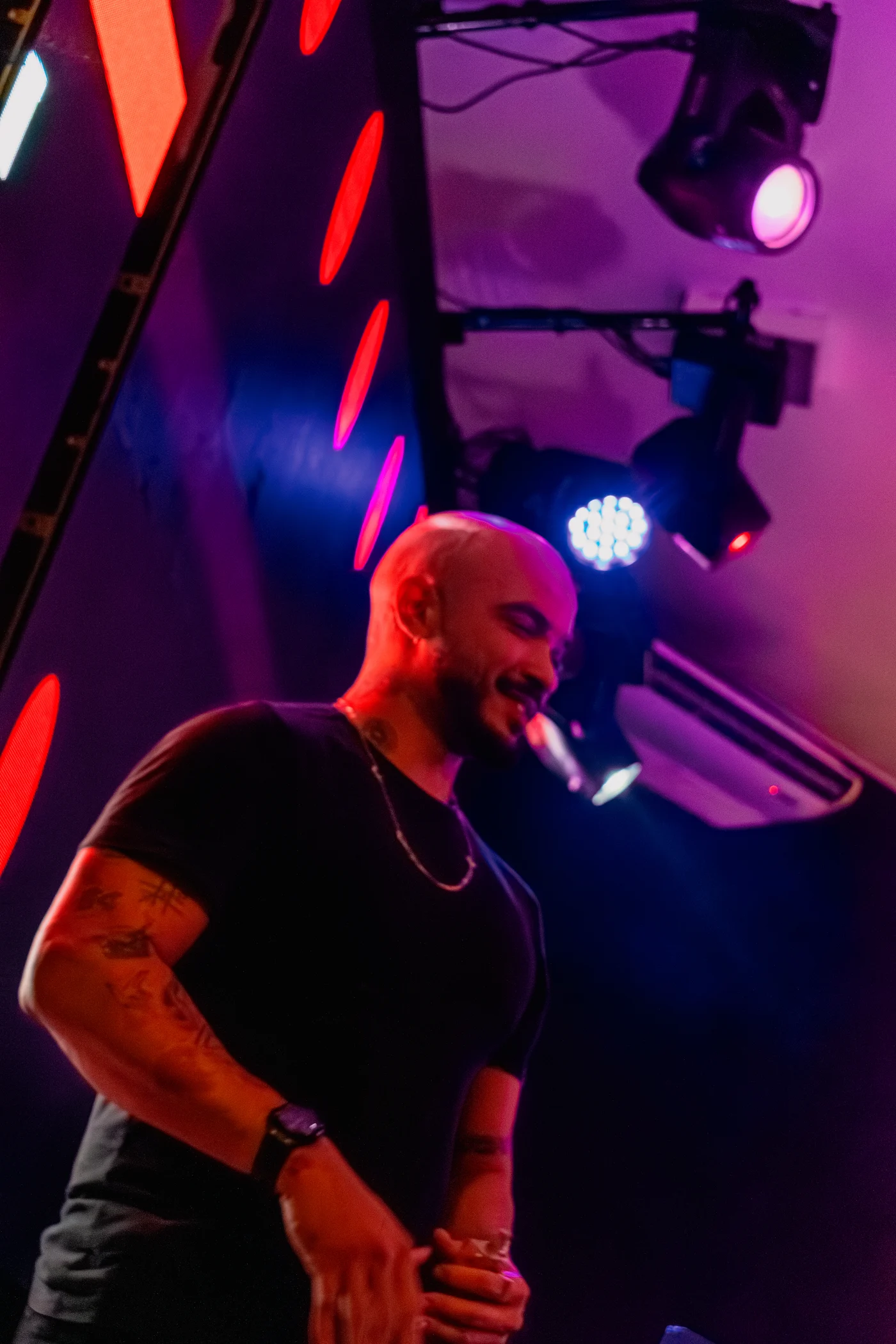 Davi Santos em apresentação diante dos equipamentos de DJ e da iluminação de palco.